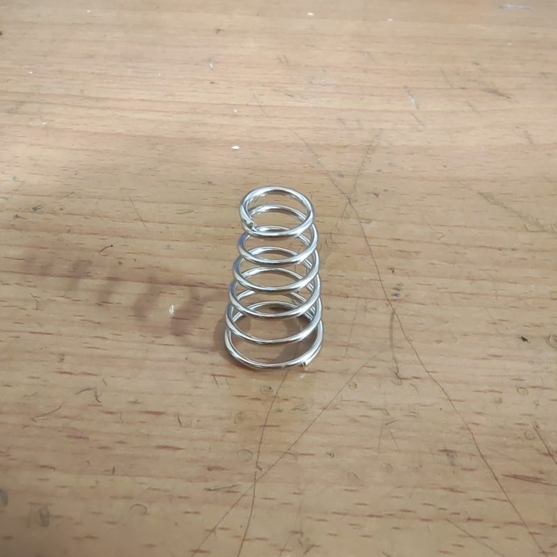 Clamp spring for zipper machine material feed system